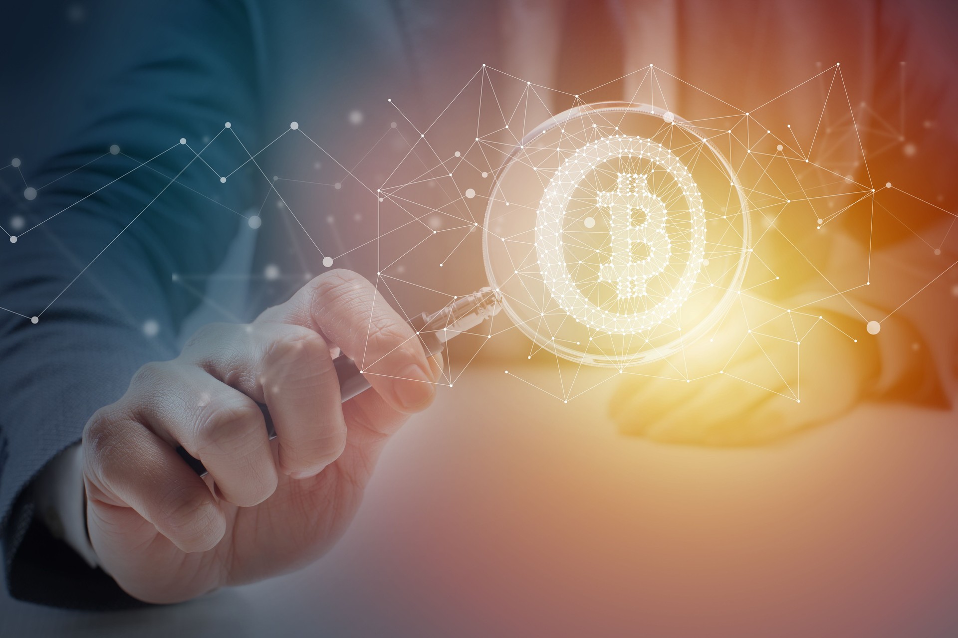 Businessman at Desk Looking Through Magnifying Glass at Bitcoin Symbol